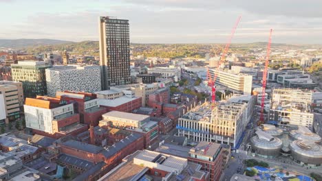 Aerial-approaching-shot-of-Sheffield-City-with-construction-Site-and-cranes-during-sunny-day
