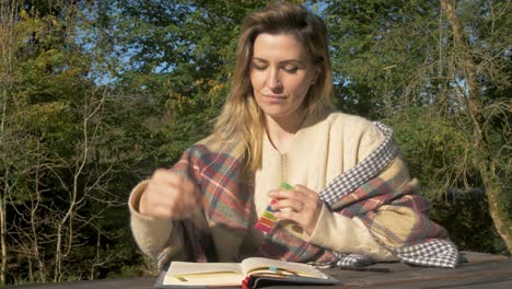 Ukrainian-woman-marking-notebook-page-studying-outdoors