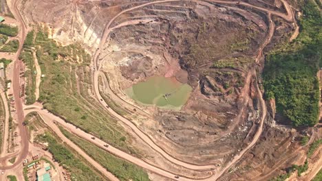 A-wide-aerial-drone-shot-of-dirt-roads-winding-around-the-main-quarry-of-Siana-Gold-and-Silver-Mine,-Mainit,-Philippines