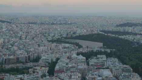 Weitläufige-Luftaufnahme-über-Athen-Mit-Grünen-Hügeln-Und-Stadtflächen