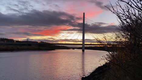 Die-Nördliche-Turmbrücke-über-Dem-Fluss-Trägt-Sich-Während-Eines-Wunderschönen-Orangefarbenen-Sonnenuntergangs