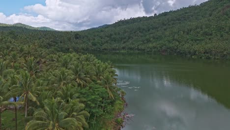 An-aerial-drone-shot-over-Mahucdam-Lake,-with-tropical-jungle-covered-hills-surrounding-the-water