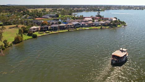 The-paddle-steamer-Cumberoona-approaching-the-houses-on-Cypress-Drive-Mulwala,-NSW,-Australia