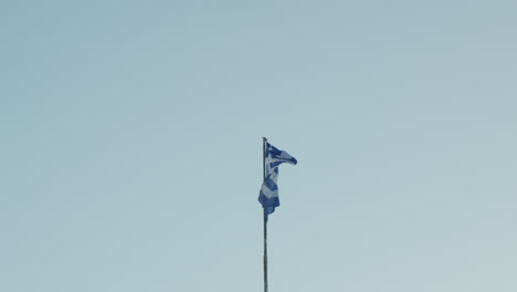 Greek-flag-waving-proudly-against-a-clear-blue-sky