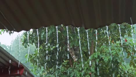 Heavy-rain-streaming-from-a-tin-roof-during-a-tropical-storm,-monsoon-season-in-The-Philippines