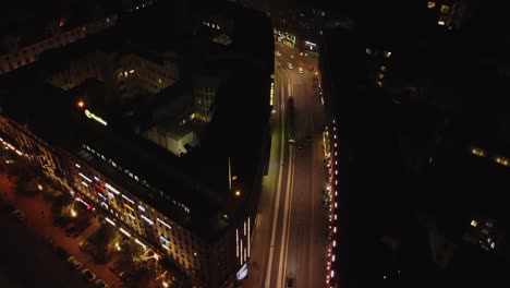 Aerial-follows-traffic-on-winding-illuminated-Helsinki-street-at-night