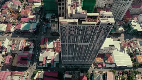 Aerial-view-looking-down-onto-city-buildings-and-apartment-blocks-in-Phnom-Penh,-Cambodia
