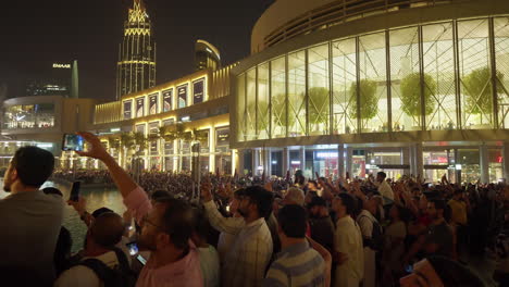 Crowded-plaza-with-people-filming-a-nighttime-event-in-Dubai