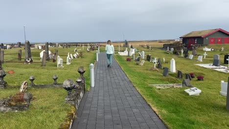 Blondes-Mädchen,-Das-Respektvoll-Zwischen-Gräbern-Auf-Dem-Isländischen-Friedhof-Spaziert