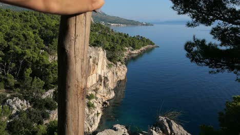 Hiker-on-top-of-cliff-with-unspoiled-Mediterranean-coastline-mountain-sea-view