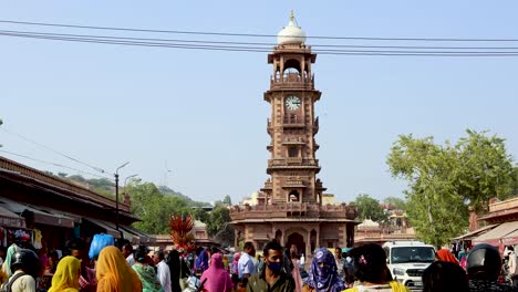 Menschen,-Die-Tagsüber-Aus-Einem-Anderen-Blickwinkel-Auf-Einer-überfüllten-Stadtstraße-In-Der-Nähe-Des-Künstlerischen-Uhrturms-Spazieren.-Das-Video-Wurde-Am-06.-November-2023-In-Ghantaghar,-Jodhpur,-Rajasthan,-Indien,-Aufgenommen