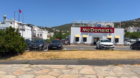 Old-style-vintage-McDonalds-storefront-in-Bodrum-Turkey,-fast-food-restaurant,-red-Turkish-flag,-4K-shot
