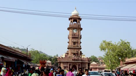 people-walking-at-crowded-city-street-near-artistic-clock-tower-at-day-from-different-angle-video-is-taken-at-ghantaGhar-jodhpur-rajasthan-india-on-Nov-06-2023