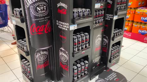 Limited-edition-Jack-Daniels-Coca-Cola-whiskey-can-ready-to-drink-cocktail-at-Carrefour-supermarket-store-in-Estepona-Spain,-popular-brands,-4K-tilting-up