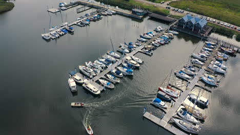 Aerial-shot-of-drone-flying-around-marina-in-Blotnik,-Pomeranian,-Poland-with-motorboats-and-yachts