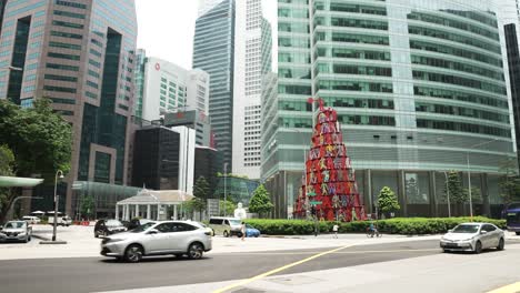 El-Tráfico-Circula-Por-Raffles-Quay-Road-Pasando-Por-La-Escultura-Momentum-En-Singapur.