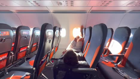 A-person-chilling,-sleeping,-relaxing-and-laying-down-with-legs-up-on-Easyjet-airplane-seats,-Easyjet-flying-experience,-people-going-on-a-holiday,-4K-shot