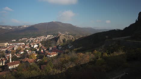 Panorama-Luftaufnahme-Von-Häusern-Im-Dorf-Belogradchik-In-Bulgarien,-Schwenk-Auf-Die-Historische-Felsformation-Und-Festung