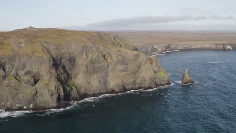 Aerial-view-of-rocky-coastline-with-Ketubjorg-cliffs-during-sunny-day-on-Iceland---Backwards-movement-flight
