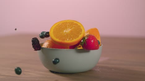 Fruit-Falls-Into-Bowl-On-Table