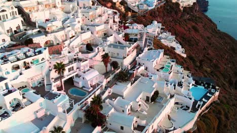 Filmische-Luftaufnahme-Des-Berühmten-Dorfes-Oia-Auf-Santorini,-Griechenland-Bei-Sonnenuntergang