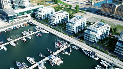 Aerial-birds-eye-shot-of-modern-buildings-at-marina-of-Gdynia-City-during-sunny-day---orbit-shot
