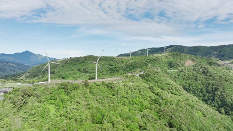 Wind-turbines-adorning-the-rolling-hills,-aerial-drone-movement-from-right-to-left