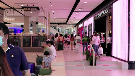 A-lobby-of-a-popular-shopping-mall-in-Bangkok,-Thailand-is-filled-with-shoppers-and-tourists-buying-the-latest-trends-in-fashion-and-designer-brands
