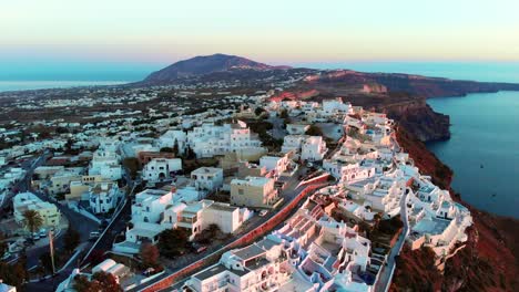 Filmische-Luftaufnahme-Des-Berühmten-Dorfes-Oia-Auf-Santorini,-Griechenland-Bei-Sonnenuntergang
