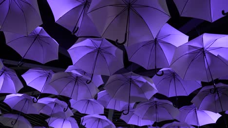Illuminated-Umbrella-outdoor-display-at-night-in-the-Futuroscope-Theme-Park,-Looking-up-shot