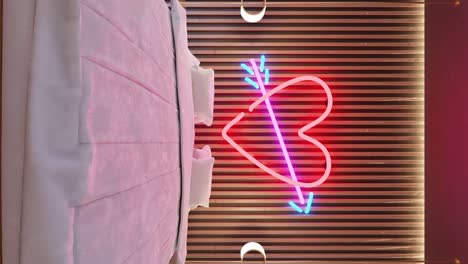 vertical-zoom-in-on-motel-hotel-room-with-white-bed-for-couple-and-led-light-heart-cupido