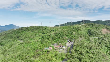 Epische-Luftaufnahmen-Von-Langgestreckten-Weißen-Windkraftanlagen-Auf-Sanften-Hügeln