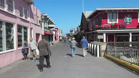 Walkers-on-Fisherman's-Wharf-with-colourful-wooden-shop-and-restaurant-houses
