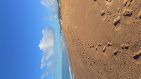 Paradise-beach,-vertical-image-footprints-in-the-sand-recorded-with-Gimbal