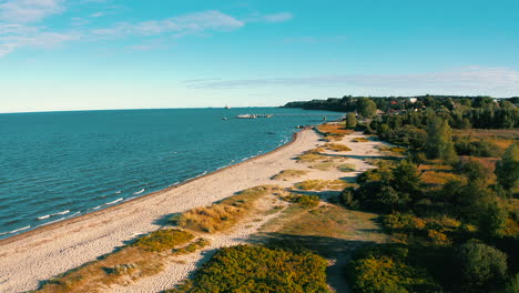 Aerial-view-of-drone-flying-above-the-beach-to-the-baltic-sea-at-the-sunset