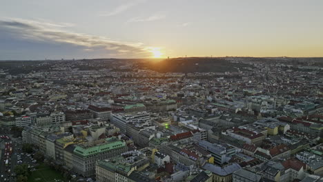 Prague-Czechia-Aerial-v62-drone-flyover-railway-station-capturing-New-town-cityscape,-grand-national-museum-and-Wenceslas-square-with-sun-sets-on-the-horizon---Shot-with-Mavic-3-Cine---November-2022
