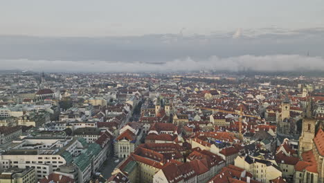 Prague-Czechia-Aerial-v134-cinematic-drone-flyover-historic-Old-town-district-capturing-morning-cityscape-with-sunrise-misty-clouds-covering-the-city---Shot-with-Mavic-3-Cine---November-2022