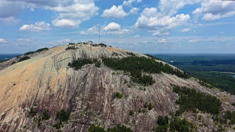 Aerial-approaching-shot-of-Stone-Mountain-park-with-granitic-rock-and-landscape-in-background---Georgia,-USA