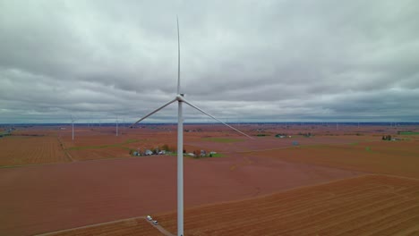 Eine-Windkraftanlage-Dominiert-Den-Vordergrund-Auf-Einem-Weitläufigen-Ackerland-In-Iowa-Unter-Einem-Weiten-Himmel