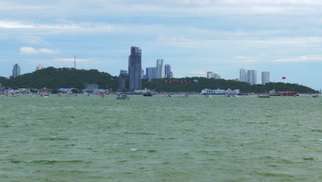 A-view-of-the-marina-and-business-center-of-Pattaya-Beach-from-across-the-gulf,-where-hotels,-condominiums,-boats,-jetski,-and-shopping-centers-are-located,-in-Chonburi-province,-Thailand