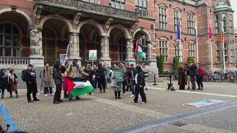 Manifestación-Pro-Palestina-Ondeando-La-Bandera-Palestina,-Estudiantes-Protestando-Frente-A-La-Universidad-De-Groningen