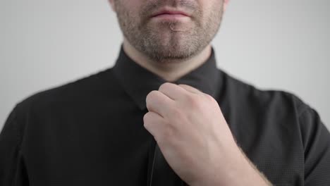 man-in-black-shirt-adjusts-his-tie