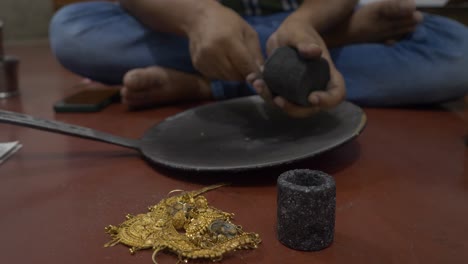 Selective-focus-of-an-Indian-goldsmith-preparing-to-melt-gold-jewelry-in-a-workshop
