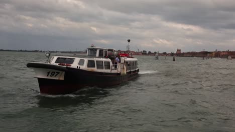 Water-Bus-ferry-boat-sails-across-lagoon-in-Venice,-Italy-on-rainy-day