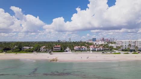Scenic-horizontal-aerial-drone-view-of-west-palm-beach-skyline-downtown-area-and-beautiful-beach-sand-and-boats-in-water