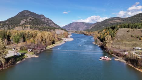Autumn-Majesty:-Scenic-Aerial-Footage-of-Thompson-River,-Cable-Ferry,-and-Forested-Mountains