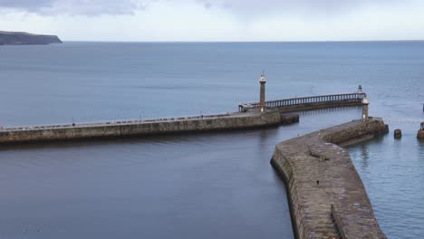 Panning-shot-of-Whitby-HArbour-revealing-the-large-walls-and-historic-city