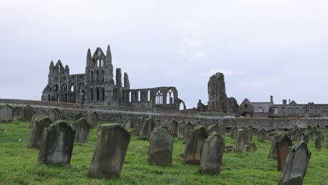 Slow-panning-shot-of-the-famous-Whitby-Abbey-ruins-with-a-cemetery-in-Yorkshire
