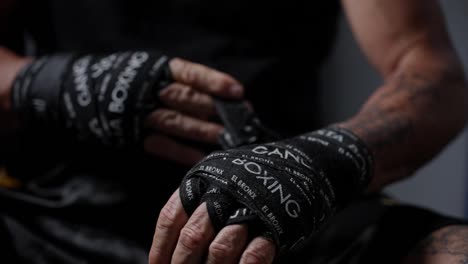 Tattooed-man-wrapping-boxing-bandages-around-his-hands