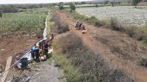 Masai-people-gather-drinkable-water-to-plastic-jugs-from-borehole-well,-Loitokitok,-Kenya